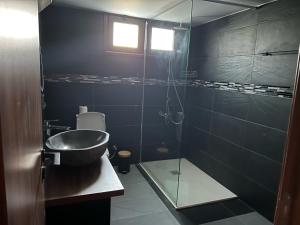 y baño con lavabo y ducha acristalada. en Maria's Apartments 1 en Galata