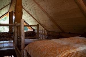 a bedroom with a bed in a attic at Brunarica Biopark -Log house Biopark in Grosuplje