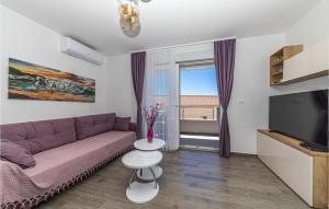 - un salon avec un canapé violet et une fenêtre dans l'établissement Awesome Apartment In Seget Donji With Wifi, à Donji Seget