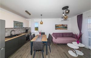 Il comprend une cuisine et un salon avec une table et un canapé violet. dans l'établissement Awesome Apartment In Seget Donji With Wifi, à Donji Seget