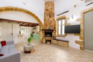 a living room with a fireplace and a tv at Mansion Fabrica in Kalleryianá