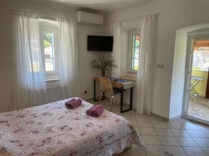 a bedroom with a bed and a desk and windows at Pjacal in Veli Lošinj