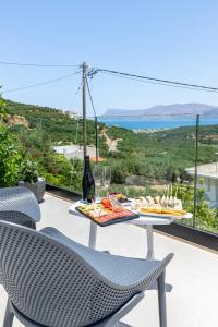 una mesa y sillas en un balcón con vistas al océano en Mansion Fabrica en Kalleryianá