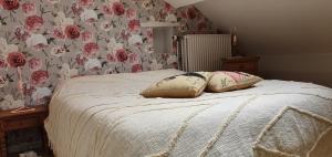 a bedroom with a bed with two pillows on it at Chambre de Amandine à Gerpinnes in Gerpinnes