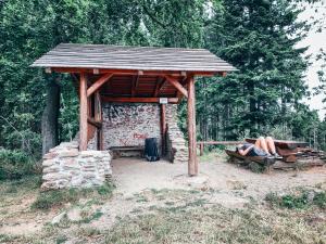 スシツェにあるHorská chata Svatoborの木造避難所の下に腰掛け