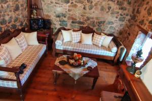 a living room with two couches and a table at MARGO'S RUSTIC HOUSE in Kalón Khoríon