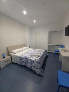 - une chambre dotée d'un lit avec une couverture bleue et blanche dans l'établissement Al delfino blu, à Margherita di Savoia