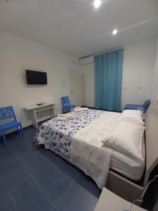 Al delfino blu في مارغريتا دي سافويا: غرفة نوم بسرير كبير مع كرسيين ازرق
