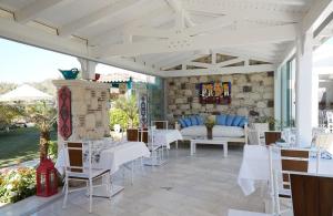 a patio with white tables and white chairs at On Oda Alaçatı in Alacati