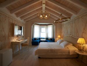a bedroom with a large bed and a blue couch at On Oda Alaçatı in Alacati
