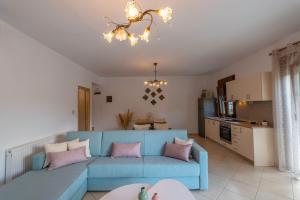 a living room with a blue couch and a kitchen at Villa Nostalgia in Skala Potamias