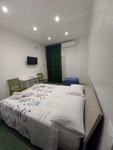 Un dormitorio con una gran cama blanca con flores. en Al delfino blu en Margherita di Savoia