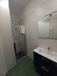 マルゲリータ・ディ・サヴォイアにあるAl delfino bluのバスルーム(シャワー、シンク、鏡付)