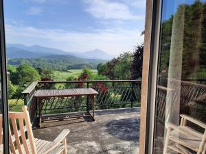 a balcony with a bench and a view of the mountains at Le Petit Chalet du Hérisson-Panorama Unique sur les Pyrénées !!! in Montespan