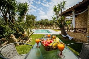 einen Obstkorb auf einem Tisch neben einem Pool in der Unterkunft Sincerity Luxury Villa in Tragaki