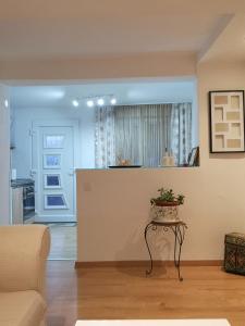 a living room with a table and a kitchen at Sweet Cosy Apartment in Matulji