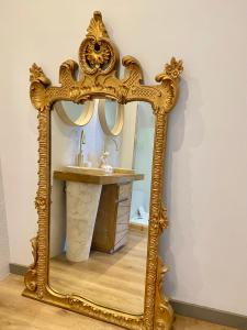 um espelho ornamentado com um lavatório na casa de banho em Coural' Chic em Narbona