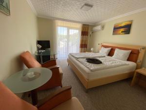 ein Hotelzimmer mit einem Bett und einem Tisch in der Unterkunft Solaris Hotel in Balatonföldvár