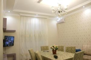 a dining room with a table and chairs and a chandelier at Golden House in Gabala