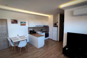 une petite cuisine avec une table et des chaises ainsi qu'une cuisine avec un comptoir dans l'établissement 4StarsDS, à Dunajská Streda