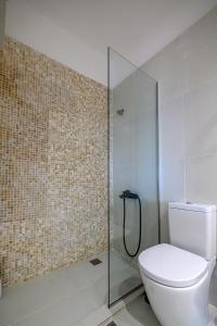 a bathroom with a toilet and a glass shower at Little cozy room by the sea in Messini