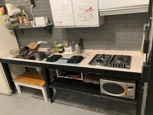 a kitchen counter with a stove and a sink at Itaewon Inn in Seoul