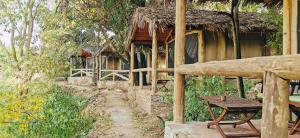 a house with a table in front of it at Fig Tree Camp - Maasai Mara in Talek