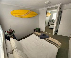 a bedroom with a bed with a surfboard on the wall at Villas Sienna Homestay in Gold Coast