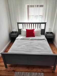 Un dormitorio con una cama con una almohada roja. en Centrum Apartament Przytulny, en Świdnica