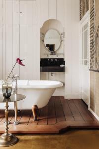 a bathroom with a white tub and a mirror at Inn on the Lake in Broek in Waterland