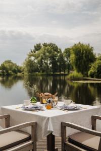a table with food and a view of a lake at Inn on the Lake in Broek in Waterland