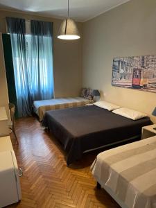 um quarto com 2 camas e uma grande janela em Tiffany Rooms em Milão