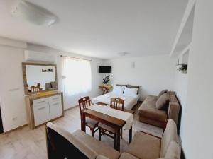 een woonkamer met een bed, een bank en een tafel bij Apartments Blazevic in Herceg-Novi