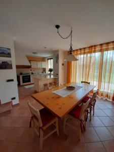 a kitchen and dining room with a wooden table and chairs at San Marcello Residence in Feltre