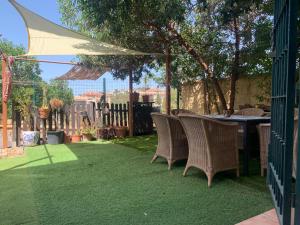 a patio with a table and chairs on grass at Apartamento con jardín y piscina en el faro de calaburras in Mijas Costa