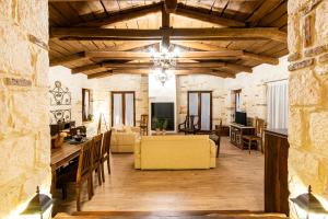 uma sala de estar com tectos em madeira e um sofá amarelo em Villa Castello em Ágios Nikólaos