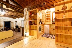 a large kitchen with wooden walls and wooden shelves at Villa Castello in Koiliomenos