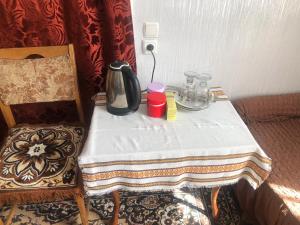a table with a tea kettle on it next to a chair at Rimma Homestay in Tbilisi City