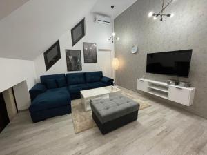 a living room with a blue couch and a tv at Apartman Carpe Diem in Jajce