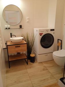 uma casa de banho com um lavatório e uma máquina de lavar roupa em Sleep In Apartament Centrum em Breslávia