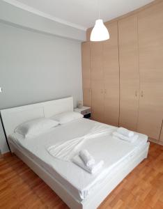 um quarto com uma cama branca com duas toalhas em Panoramic Apartment em Quios