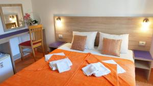 a bedroom with a large bed with towels on it at Guesthouse Tri Palme in Bečići