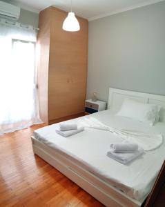 sypialnia z dużym białym łóżkiem z ręcznikami w obiekcie Panoramic Apartment w Chios