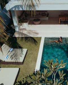 - un homme dans la piscine d'une villa dans l'établissement Kalea Villas, à Kuta Lombok