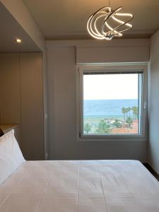 Un dormitorio con una cama grande con una ventana grande. en Il Marino - Santo Stefano, en Santo Stefano al Mare
