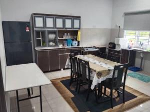 a kitchen with a table and chairs in it at Abah StayCation in Sungai Besar