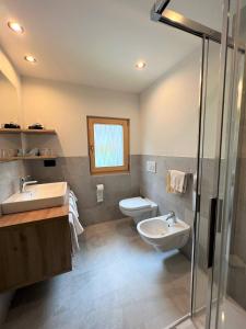 łazienka z 2 umywalkami i toaletą w obiekcie Villa Resi B&B w mieście Corvara