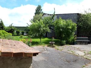 a garden with a bench and a building at Gite des 3 Cailloux in Leulinghen-Bernes +6 photos