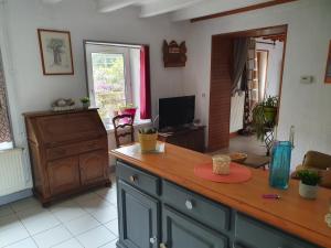a kitchen with a counter and a living room at Gite des 3 Cailloux in Leulinghen-Bernes