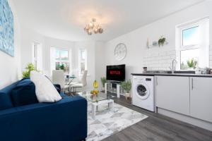 a living room with a blue couch and a kitchen at 2 Bedroom Apartment in Darlington with Free Parking & Smart TV in Darlington